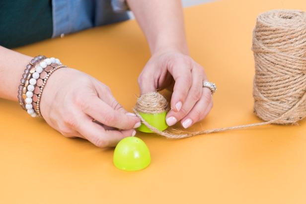 Twist the twine around the egg, applying hot glue on the low setting as you twist. Make sure to cover the egg completely.