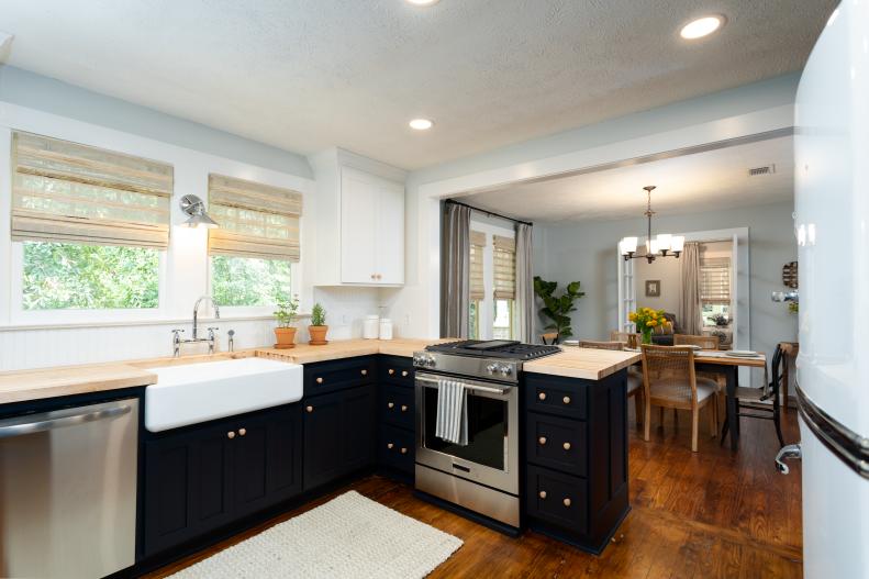 As seen on Home Town, the Guay Residence has been fully renovated by Ben and Erin Napier in Laurel, Mississippi.  The old kitchen was small and closed off with very little cabinet storage.  The renovated kitchen now opens to the dining area and a new wall of cabinetry has greatly increased the look and feel of the kitchen.  The dark cabinet color adds a strong contrast to the open floor plan, complementing the updated design of the house. (after)