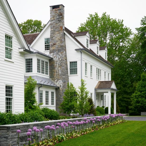 white colonial home with large stone chimney hgtv
