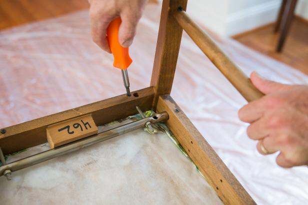 Remove the seat cushion from the chair frame using a screwdriver.