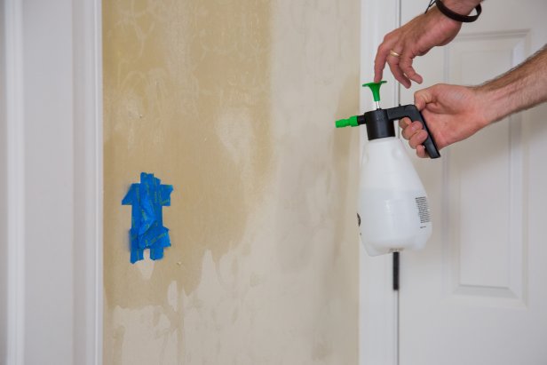 Once you’ve removed all of the wallpaper, you may notice some adhesive left on the walls. Remove it by going over the walls one more time with the hot water solution and scraper. Cover the electrical outlet with painter's tape, spray a four-foot-wide section and work the scraper along the surface of the wall, removing the final bits of glue.