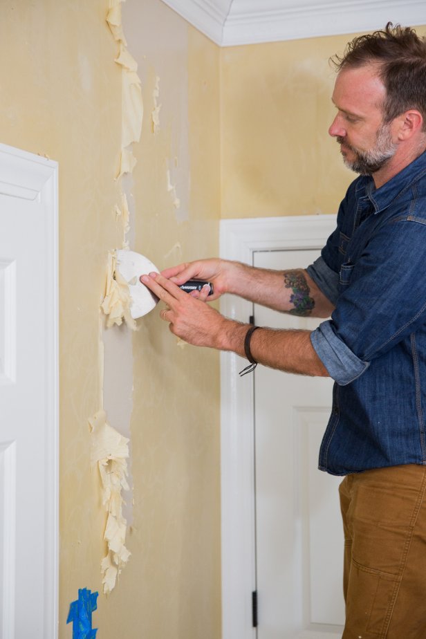 Once you’ve removed all of the wallpaper, you may notice some adhesive left on the walls. Remove it by going over the walls one more time with the hot water solution and scraper. Cover the electrical outlet with painter's tape, spray a four-foot-wide section and work the scraper along the surface of the wall, removing the final bits of glue.