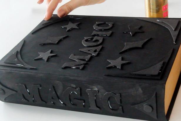 Use tacky glue to adhere letters and embellishments to the front of the top book box.