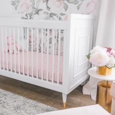 White Nursery Crib With Floral Wallpaper