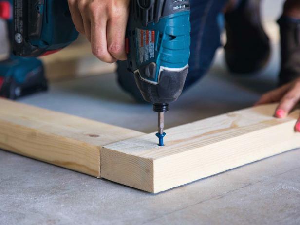 Use a ¼” masonry bit to pre-drill holes in the concrete at the corners of where the base will sit. Secure the boards to the ground with concrete anchors.