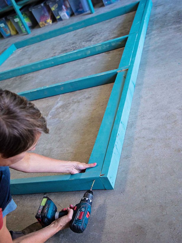 Next, screw in pieces of 2x4 to the top of the frame under the top board. This will allow the structure to better secure to the studs.