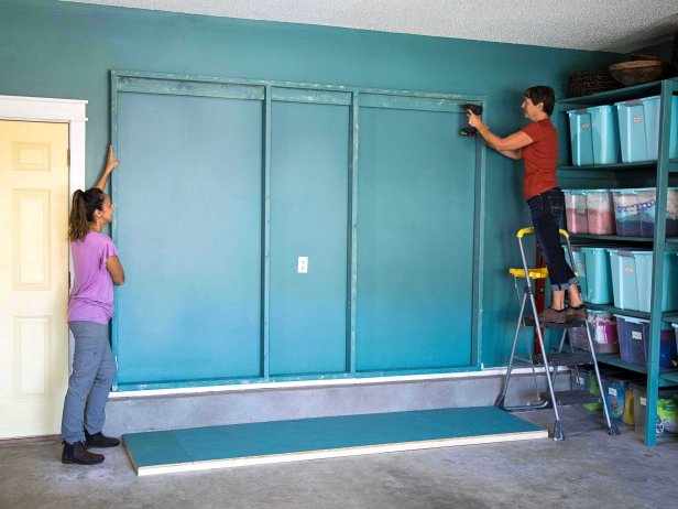 Have a friend help you raise the frame to the wall. Secure it to the marked studs using wood screws.