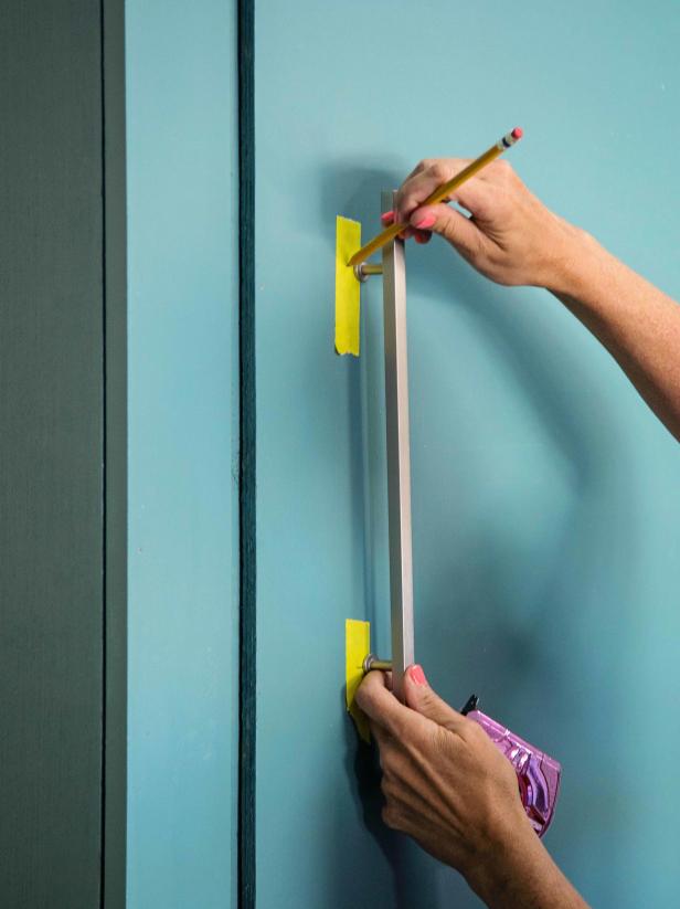 Attach your desired cabinet pulls to the doors by marking guide holes with a pencil then screwing the pulls into place.