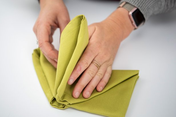 Impress your guests this holiday season with a Christmas tree-shaped napkin at the table.