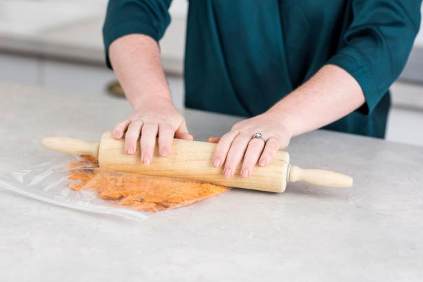 Using a rolling pin, crunch crackers into a fine powder.
