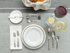 A Table Arrangement of White Plates with Flatware