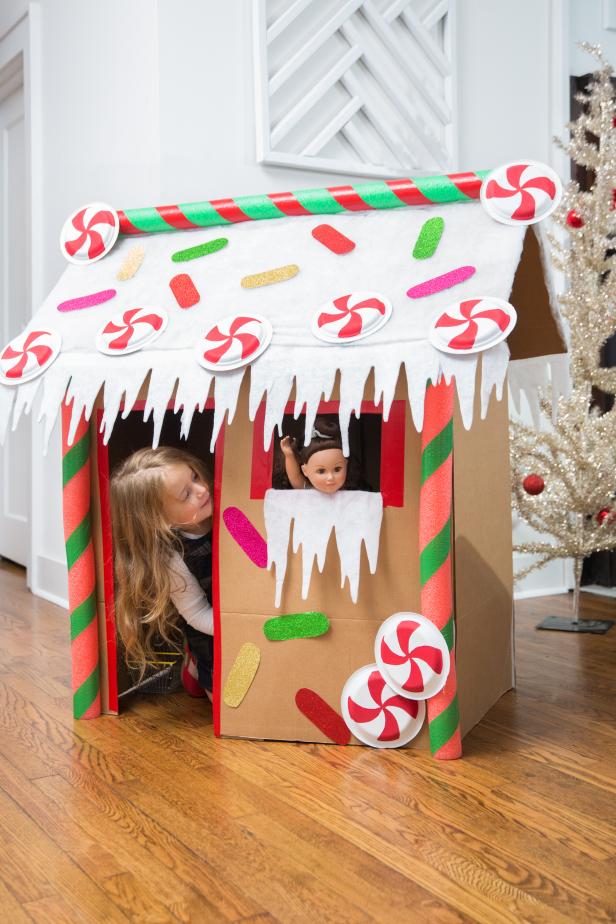 A Young Child Playing in a Cardboard Gingerbread Playhouse