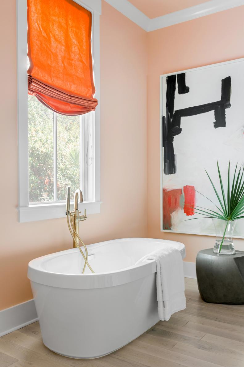 White Soaker Tub Next to Window in Pink Master Bathroom