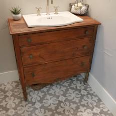 Wood Vanity and Hand-Laid Tile Floor Add Style to Bathroom