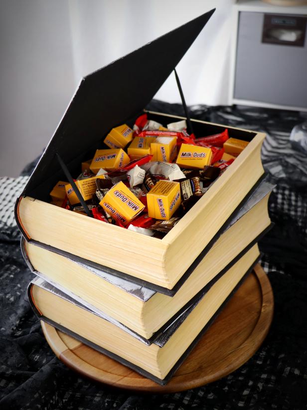 Karen Kavett hollowed out and glued together three book boxes to make this candy bowl for Halloween. She painted dowels black to prop it open.