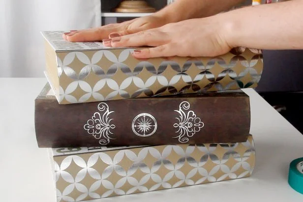 Begin this project by stacking three large book boxes on top of each other, using masking tape to temporarily hold them in place.