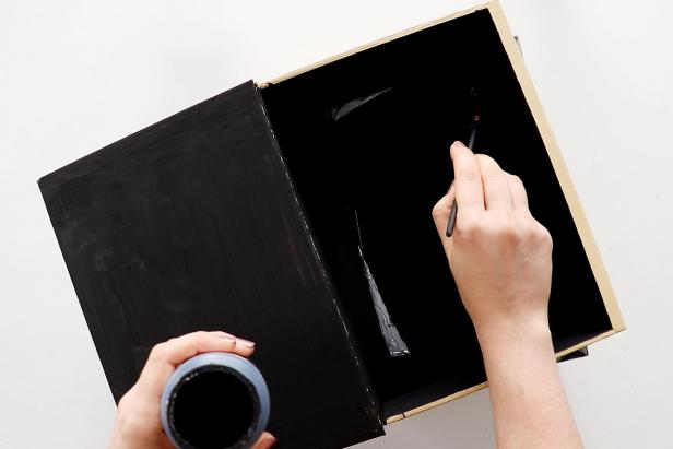 Once the glue is dry, open up the top book and touch up any bare spots with black paint. Let dry completely.