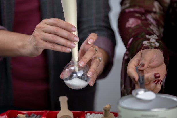 Use a funnel with a narrow opening to fill one-third of a clear ornament with hot cocoa mix.