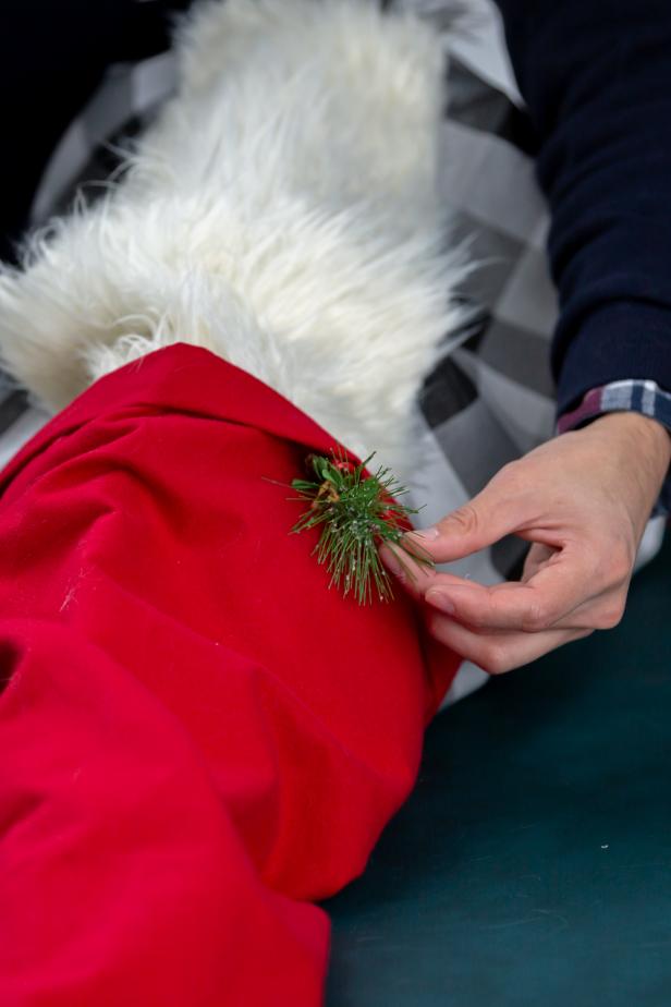 Then, glue a sprig of faux evergreen or holly inside the lip of the hat for a little extra Christmas cheer.