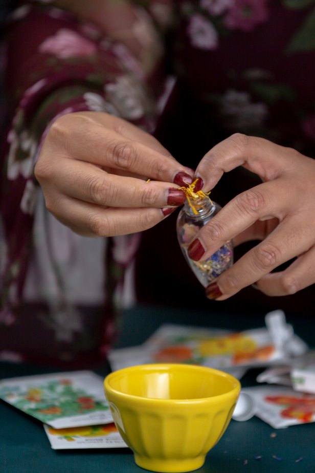 After adding seeds, fill the remaining space in the ornament with dried flower petals. Secure the lid and add a hanger if desired.