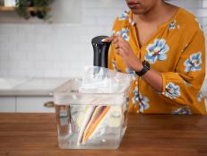Woman using sous vide wand in the kitchen