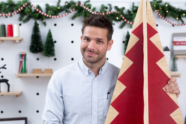 Man Standing With Painted Wooden Christmas Tree 