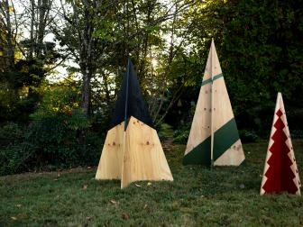 Three Plywood Christmas Trees in Varying Heights Displayed in Yard 