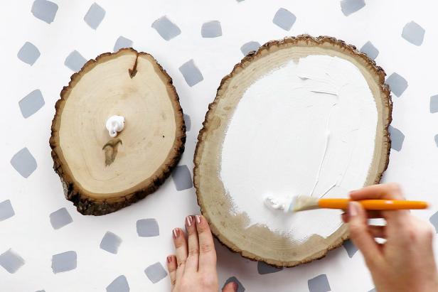 Paint the center of two wood slices white.
