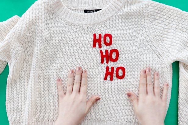 Embellish a plain white sweater with a couple pieces of felt to make a cute Santa-inspired sweater for the holidays.