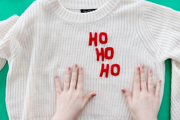 Embellish a plain white sweater with a couple pieces of felt to make a cute Santa-inspired sweater for the holidays.