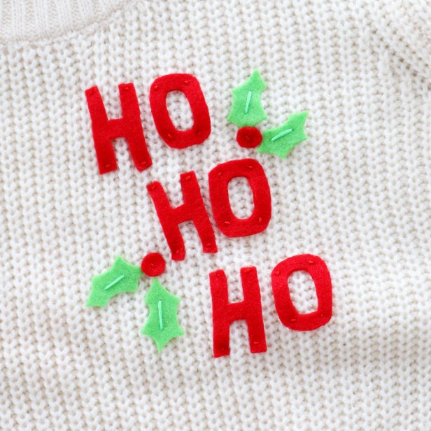 Embellish a plain white sweater with a couple pieces of felt to make a cute Santa-inspired sweater for the holidays.