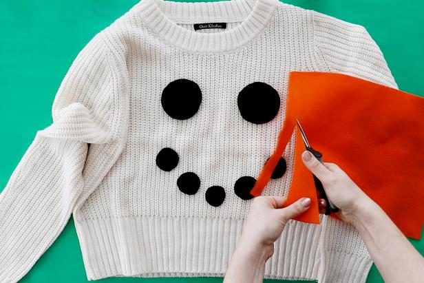 Embellish a plain white sweater with a couple pieces of felt to make a cute snowman sweater for the holidays.