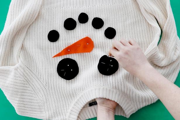 Embellish a plain white sweater with a couple pieces of felt to make a cute snowman sweater for the holidays.