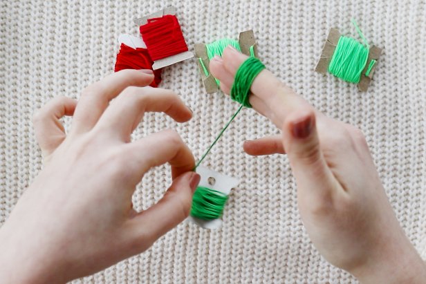 Embellish a plain white sweater with a red and green tassels to make a cute and festive sweater for the holidays.