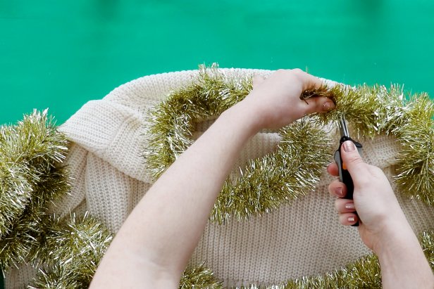 Embellish a plain white sweater with metallic tinsel to make a cute and festive sweater for the holidays.