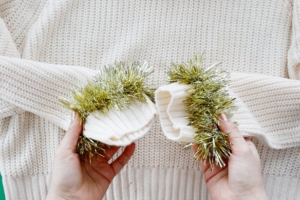 Embellish a plain white sweater with metallic tinsel to make a cute and festive sweater for the holidays.