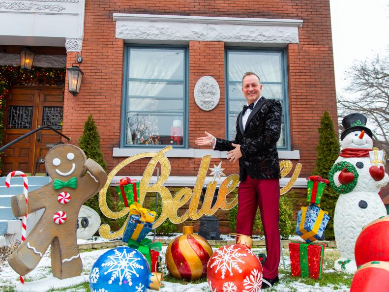 Homeowner, David Brown poses in front of his heavily decorated home, as seen on Outrageous Holiday Houses.