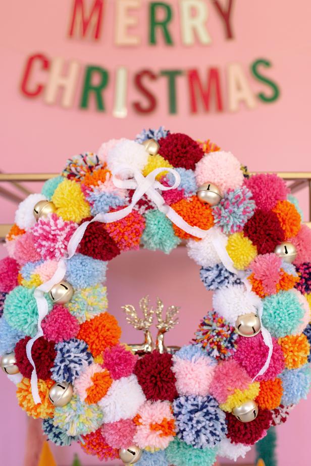 Celebrate the ho-ho-holidays with this festive pom-pom wreath that’s as merry and bright as Rudolph’s nose.
