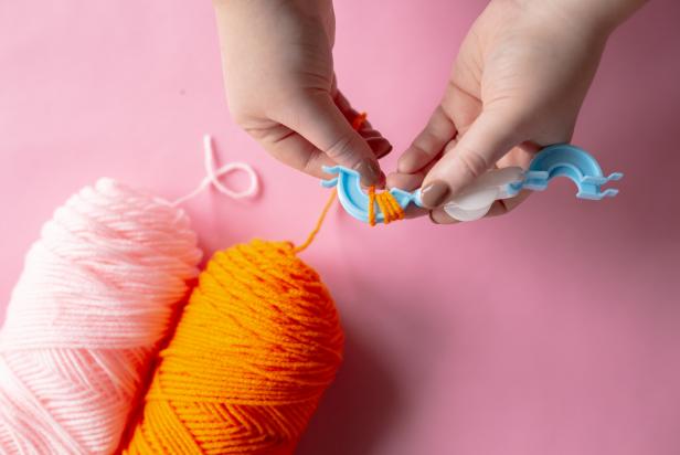 To create a two-toned pom-pom, follow the same basic instructions as the step above. Wrap one color of yarn around the first arm of the pom-pom maker until full.