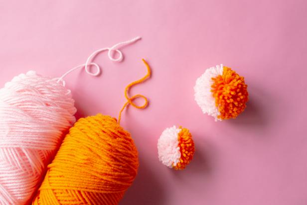 Cut a piece of yarn and tie around the pom maker, open the arms and pull them apart to reveal the two-toned pom-pom.