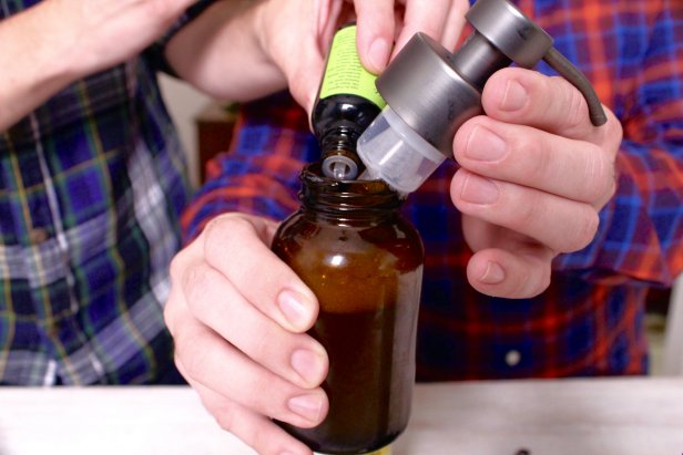 Hands Adding Oils To Dispenser With Cap Removed