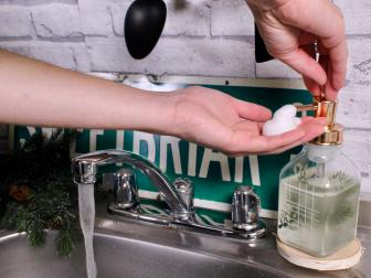 Hand Pumping Foam Soap From Dispenser Into Other Hand