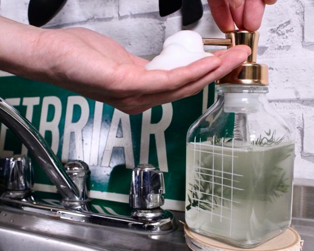 One Hand Pumping Foaming Soap From Dispenser Into Other Hand