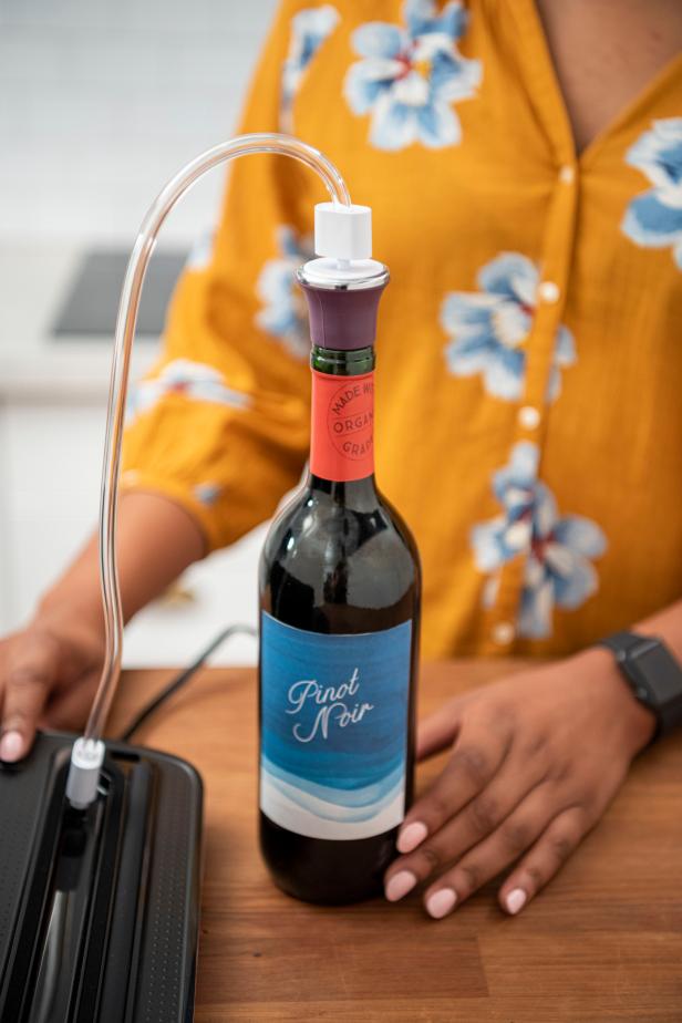 Woman using vacuum sealer for a bottle of wine