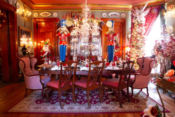 Homeowner David Brown's holiday decorated dining room features two large nutcrucker ornaments standing on the dining room table, as seen on Outrageous Holiday Houses.