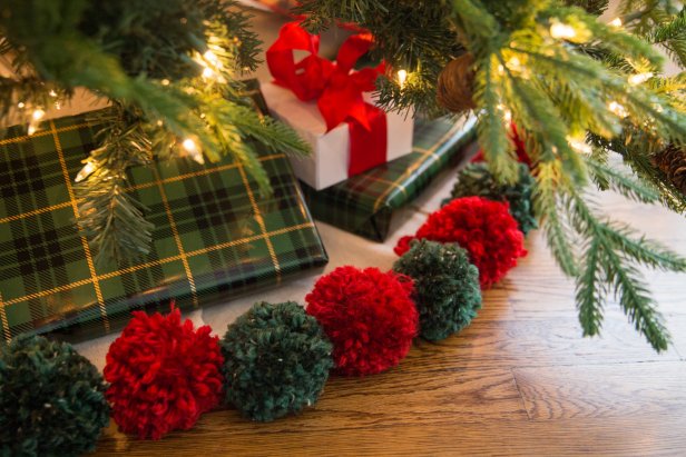 A Christmas Tree Surrounded by Yarn Pompoms on a Tree Skirt