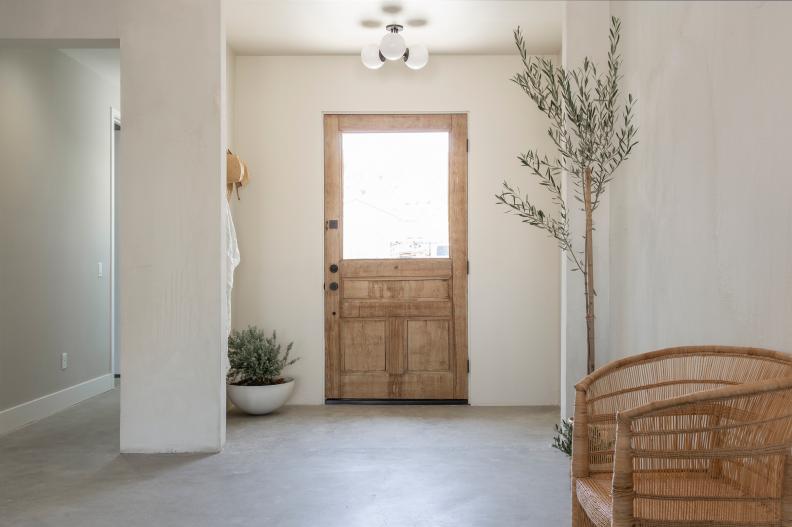 HGTV star Leanne Ford extended the space toward the front of the house, and created a minimalist bare concrete floor to complement her trademark white on white design to transform the entry way of her house, as seen on Rock the Block. (After)