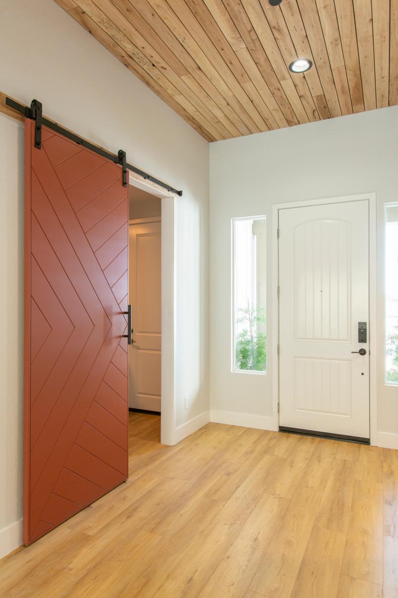 As seen on Rock the Block, HGTV star Jasmine Roth used new flooring, recycled wood on the ceiling, and a custom built barn door to transform the entry way of her house and “rock” it to the highest increase in market value to win season one of Rock The Block. (After)