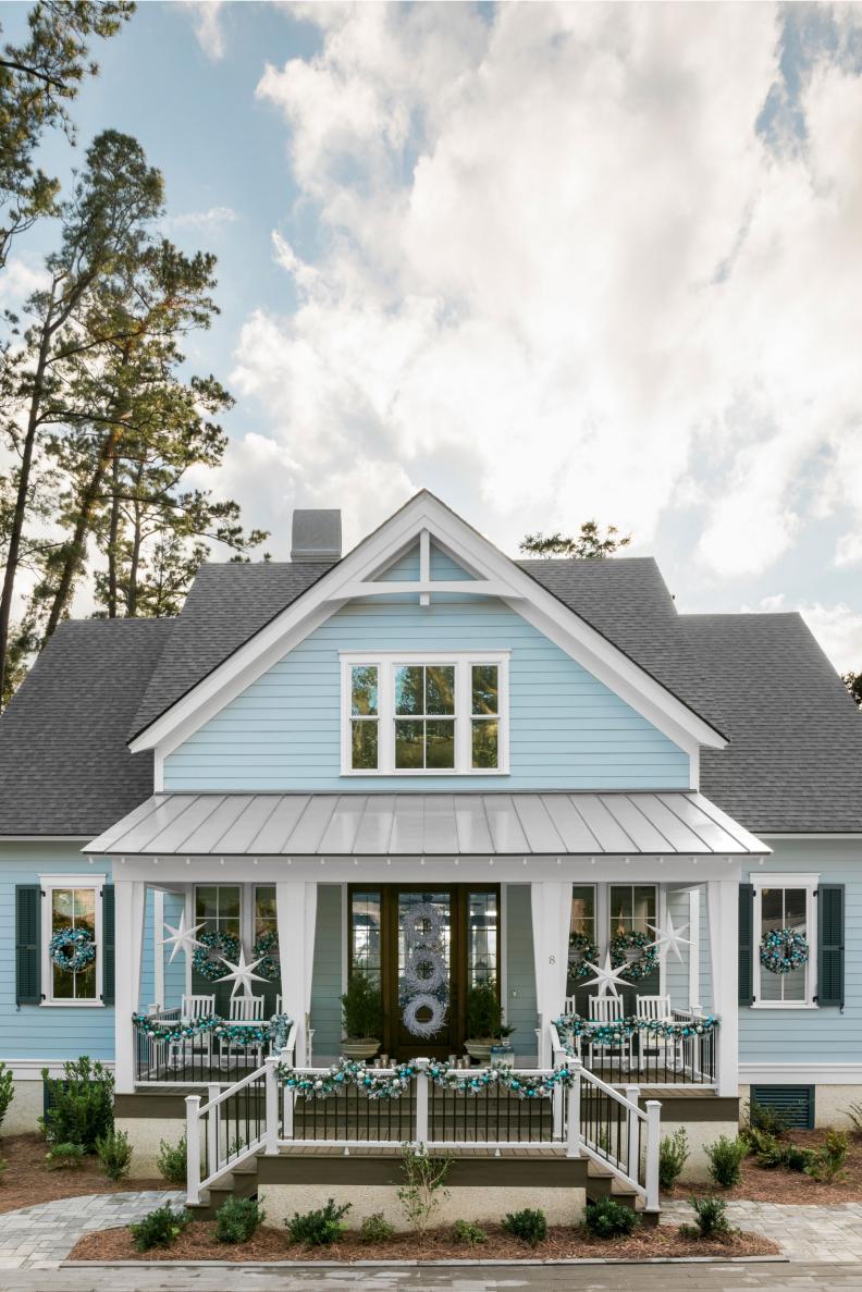 Garland Adorns Front Porch of Blue Coastal House