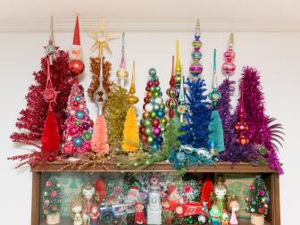Rainbow of miniature Christmas trees topped with vintage finials